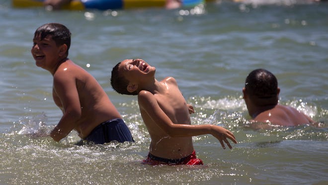 Swimmers play Monday in the swimming portion of Farmington Lake.