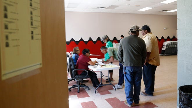 Voters line up to receive their ballots Tuesday during the Navajo Nation's primary election at the Tse Daa K'aan Chapter house in Hogback.