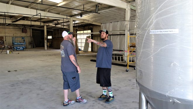 Brandon Beard, right, owner and brew master at the Lauter Haus Brewing Company, discusses a detail of the operation with one of his partners, Brad Foley, on Friday.