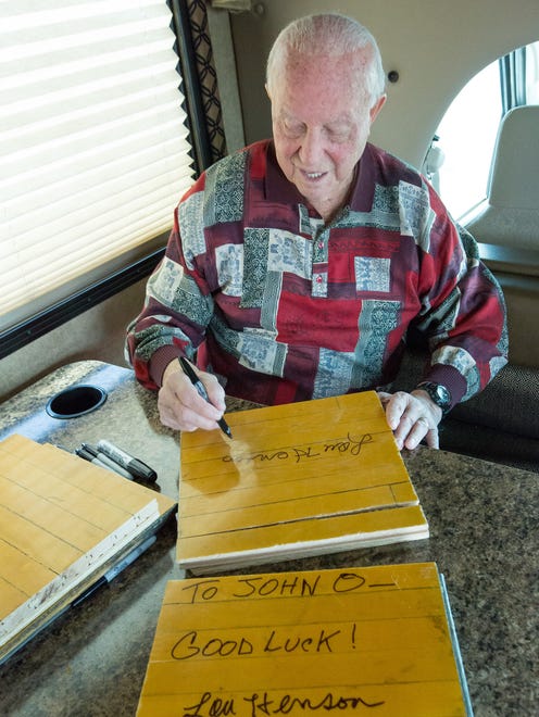 NMSU's Hall of Fame college basketball coach Lou Henson signs 12-by-12 sections of the former Pan American Center's parquet floor on Saturday, May 6, 2017. Pieces of the floor were auctioned off at Ashley Furniture HomeStore of Las Cruces.