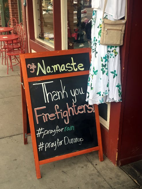 A business owner's sign on Main Avenue in downtown Durango, Colorado, thanks firefighters who are battling the 416 and Burro fires.