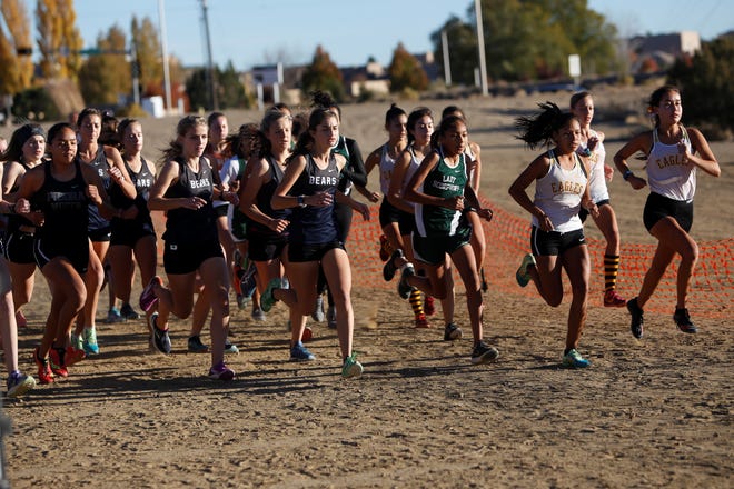 Competitors in the girls race take off from the starting line at the District 2-5A cross country championships Friday at Pinon Hills Community Church in Farmington.