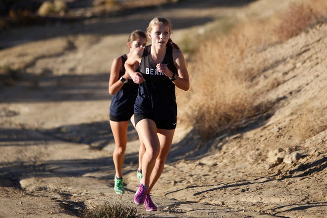 La Cueva's Brynn Esplin pushes past teammate Audrey Napier to take third place in the girls race at the District 2-5A cross country championships Friday at Pinon Hills Community Church in Farmington. Esplin's time was 23:01.68.