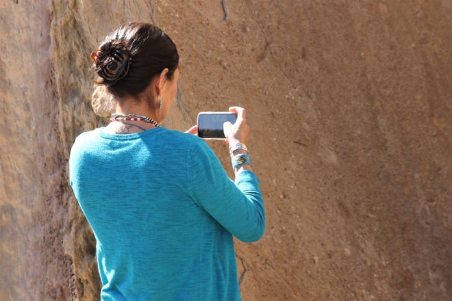 U.S. Rep. Deb Haaland, D-NM, takes pictures of fossils on a rock, Sunday, April 14, 2019, during a tour of Pueblo Bonito at Chaco Culture National Historical Park.
