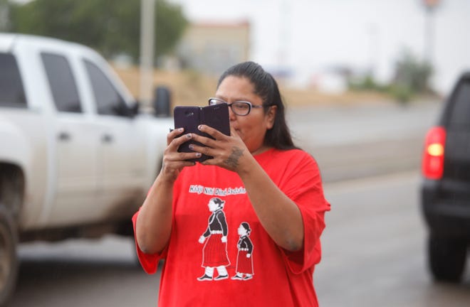 Michelle Huskay, an office assistant with the Navajo Nation Strengthening Families Program in Shiprock, takes a photograph on May 23, 2019 of participants in the missing and murdered Indigenous women and girls awareness walk in Shiprock.