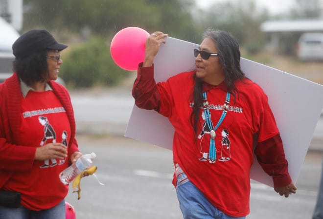 Gary Mike, father of the late Ashlynne Mike, carries a sign that displays images of missing persons during the awareness walk for missing and murdered Indigenous women and girls on May 23, 2019 in Shiprock.