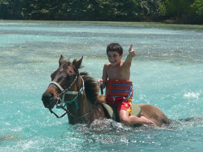 Riding horseback in the ocean is an iconic Jamaican experience.