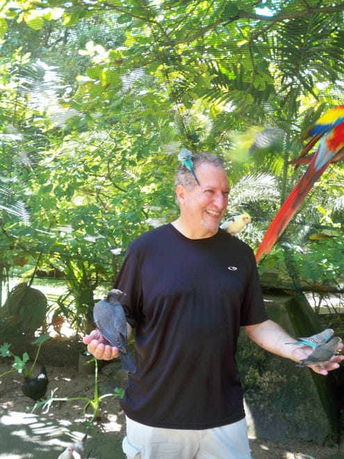 Author Mark Rogers makes some new feathered friends at Enchanted Gardens in Ocho Rios.