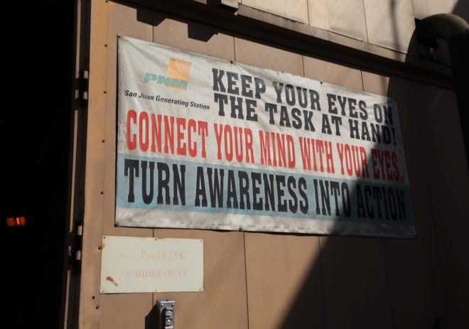 A sign is seen on an outside wall of the San Juan Generating Station.