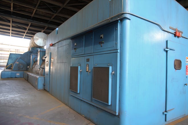 These blue boxes house the generator, which, is seen in the foreground, and the turbines, which can be seen in the background.