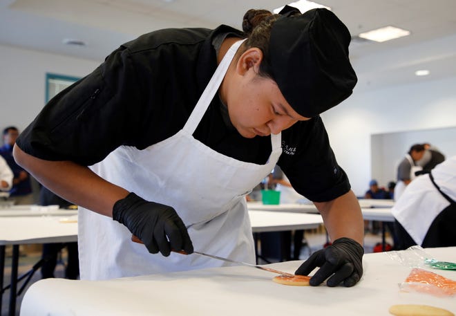 Dejaunrei Yazzie, a student at Greyhills Academy in Tuba City, Arizona, decorates a cookie during the baking competition at Skills Fest on Oct. 22 at Navajo Technical University in Crownpoint.