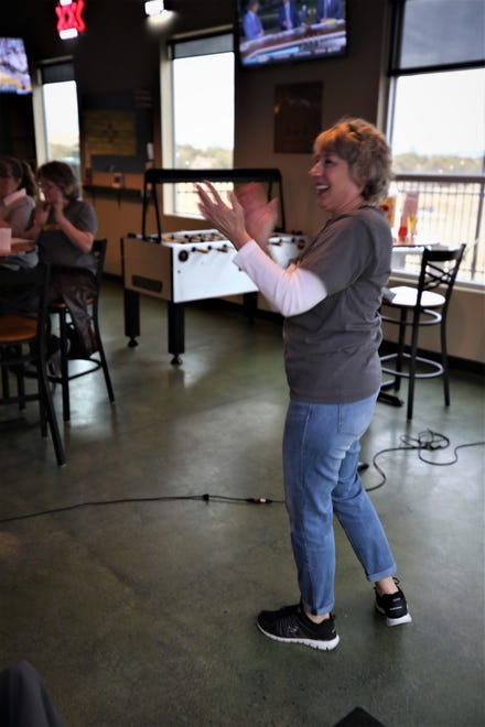 Virginia Nickels-Hircock, cofounder of the Farmington Beer Choir chapter, leads participants in a song during a March 11 gathering at Traegers bar.
