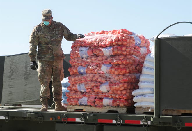 New Mexico Army National Guard member Pfc. Edwin Rodriguez helps remove a pallet of onions during a food delivery from the State of New Mexico to the Navajo Nation on April 15, 2020 in Sheep Springs.