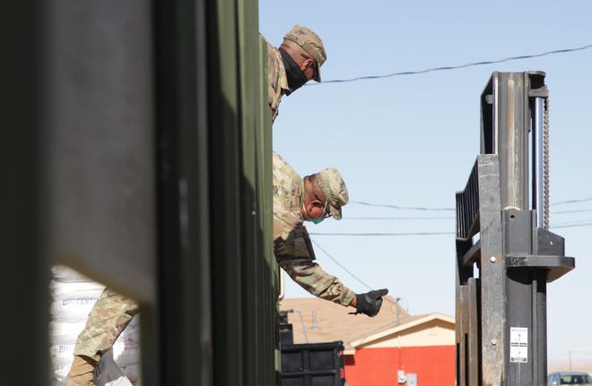 New Mexico Army National Guard member Pfc. Edwin Rodriguez gives the OK for the forklift to move on April 15 in Sheep Springs.