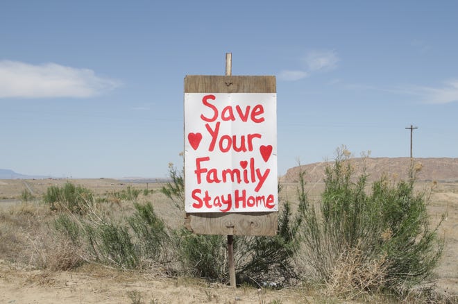 A homemade sign reminds motorists on Navajo Route 36 on April 25 to follow the stay at home order by the Navajo Department of Health to combat the coronavirus.