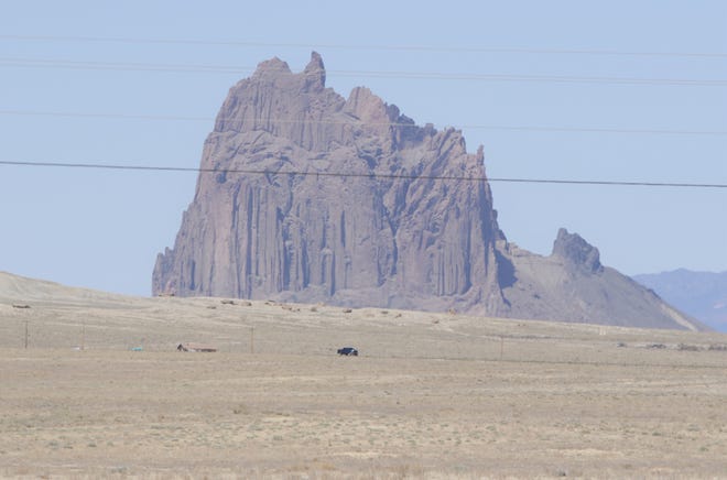 A pickup truck travels on Navajo Route 13 near the Shiprock pinnacle on April 25. Travel has been reduced to essential due to the Navajo Nation being under a weekend curfew to combat the spread of the coronavirus.