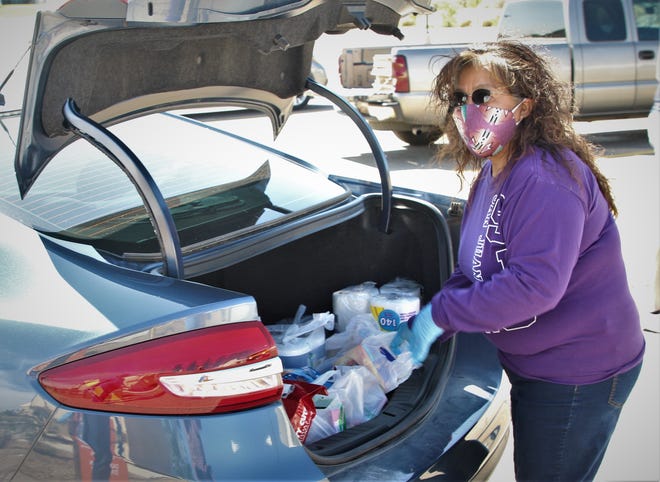 Shirley Hoskie, the operations coordinator for the San Juan College physical plant, prepares to unload a trunkful of goods May 8 on the college campus during a donation drive for people on the Navajo Nation struggling from the COVID-19 shutdown.