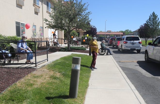 Drivers circle The Bridge at Farmington assisted living center on May 13, 2020, during the Parking Lot Love Parade.