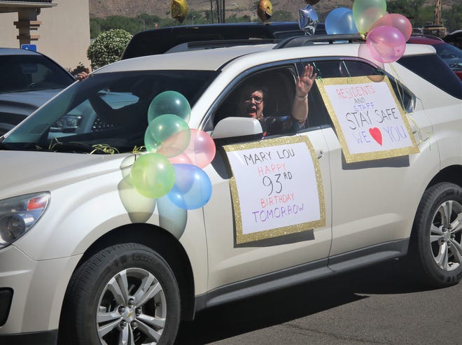 A participant in the Parking Lot Love Parade waves to residents of The Bridge at Farmington assisted living on May 13, 2020.