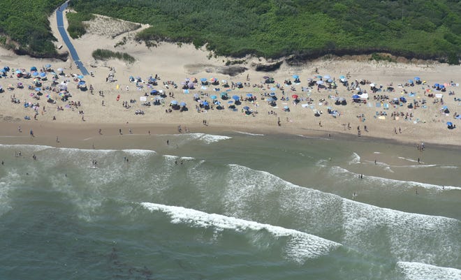 Coast Guard Beach in Eastham, Mass. also remains open, as it is a part of the Cape Cod National Seashore. Public buildings at beaches included in the Cape Cod National Seashore are closed. Visitors are seen here on July 25, 2019 in an aerial image.