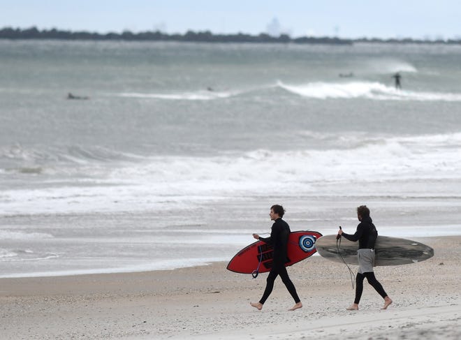 Surfers walked to the water in Wrightsville Beach, N.C., Monday, April 20, 2020. The town opened their public access points on the beach and sound side on April 20. The beach is known for its resorts and restaurants.
