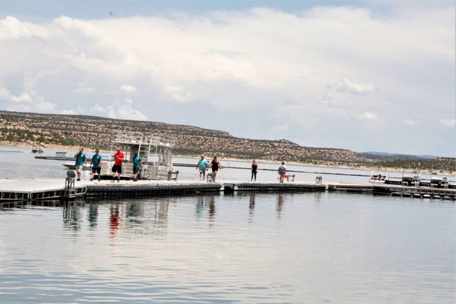 Visitors walk along the docks at the Navajo Lake State Park marina, Monday, June 1, 2020.