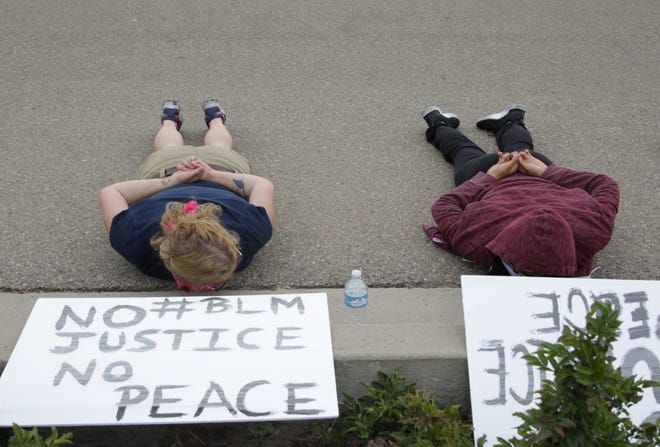 From left, Pamela Lee and Lana Tolino participate in a moment of silence for George Floyd during a peaceful protest for Black Lives Matter in front of the Farmington Museum at Gateway Park on June 5 in Farmington.