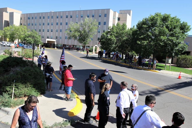People line the road, Sunday, June 14, 2020, in front of San Juan Regional Medical Center as they wait for a procession bringing Glovis Foster, a paramedic who died in Albuquerque, home to Farmington. He died June 12, 2020, after battling COVID-19.