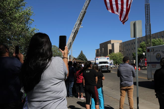 Onlookers film the procession, Sunday, June 14, 2020, as Glovis Foster's body is brought back to Farmington.