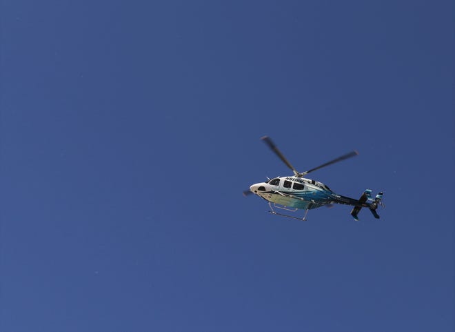 The San Juan Regional Medical Center AirCare helicopter flies over Glovis Foster's procession, Sunday, May 14, 2020, as first responders, family members and friends escorted his body back to Farmington.