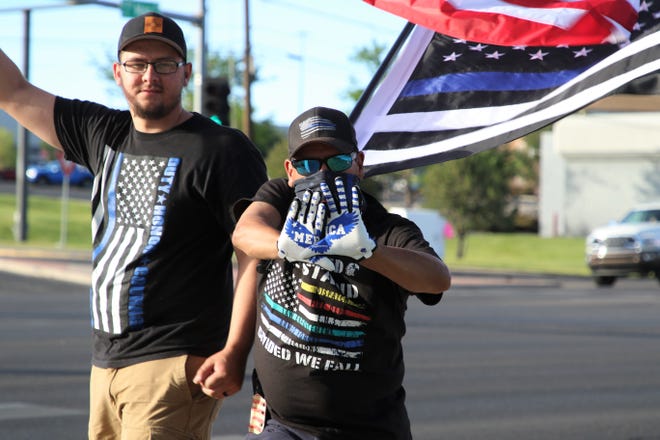 Shawn Pena, center, and David Pena, left, stand on the sidewalk along eastbound Main Street during a "Back the Blue" law enforcement rally on Friday, June 19, 2020, at the Animas Valley Mall in Farmington.