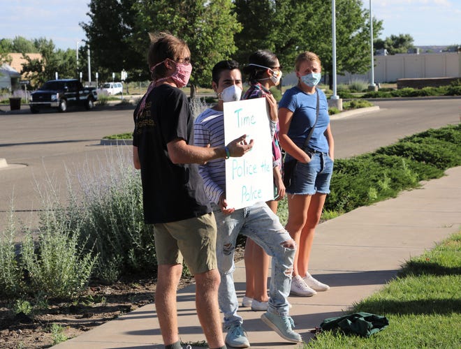 Demonstrators stand in front of the Farmington Museum at Gateway Park during a protest on Friday, June 19, 2020, in Farmington.