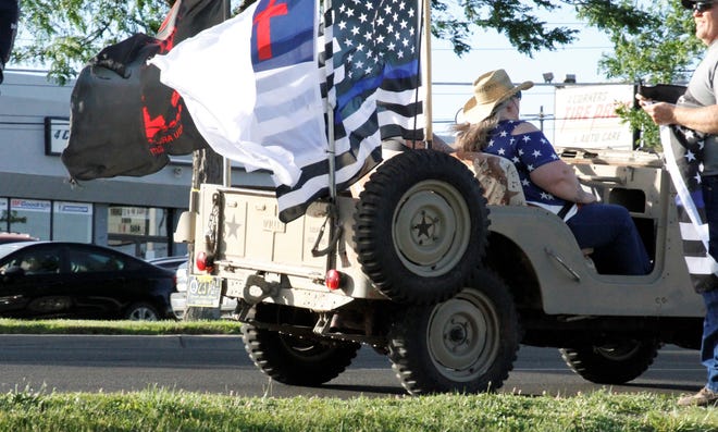 A vehicle drives by a rally in support of law enforcement, Friday, June 19, 2020, at Animas Valley Mall.