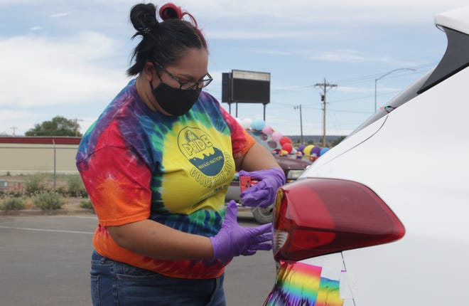 Lori Howard finishes decorating her vehicle before the start of the Diné Pride Cruise on June 26 in Window Rock, Arizona.