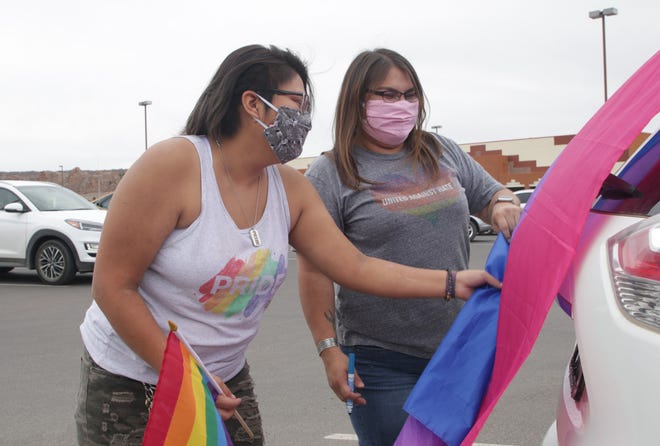 Nicole Begay, left, and Krystle Headley make last minute touches on their vehicle before the start of the Diné Pride Cruise on June 26 in Window Rock, Arizona.