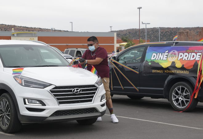 Diné Pride Operations Director Curtis Berry helps attach rainbow crepe paper to a vehicle before the start of the Diné Pride Cruise on June 26 in Window Rock, Arizona.