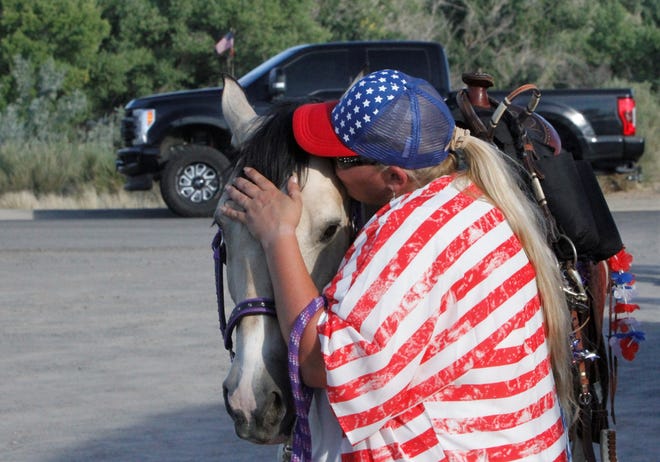 Jenny Albrecht kisses Bailey, Saturday, July 11, 2020, at the end of the Freedom March in Farmington.