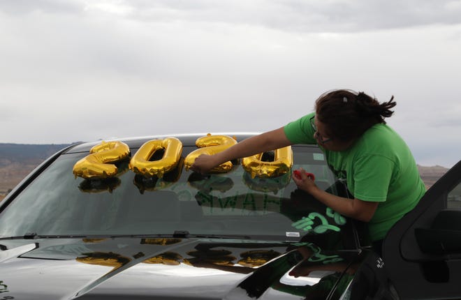 Roshana John secures balloons on her truck before the start of the parade to recognize graduates from Tsé Alnaozt'i'í Chapter on July 17 in Sanostee. John's son, Zachary John, graduated from Newcomb High School.