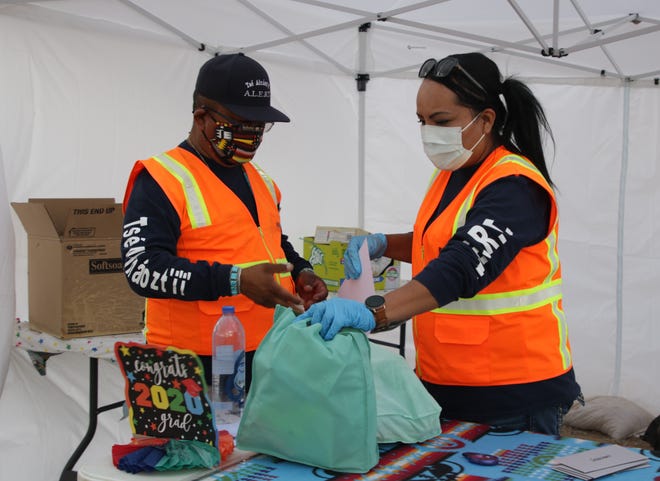 At left, Gerald Henderson and Beroncia Barber, Tsé Alnaozt'i'í Chapter's authorized local emergency response team members, organize gift bags for the community's high school or college graduates and student promotions on July 17 in Sanostee.