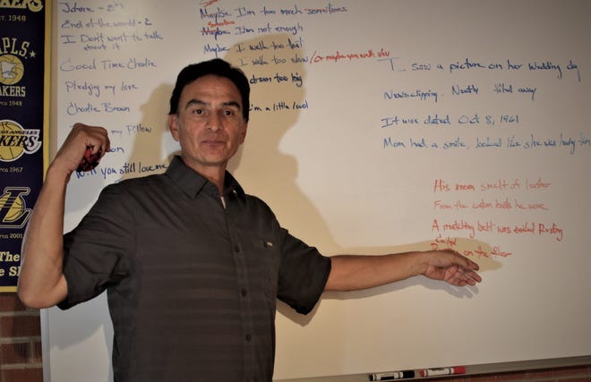 Gabriel Lucero gestures as he talks about the dry-erase board he uses to compose the lyrics for his songs.