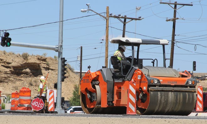 A steamroller smooths recently laid asphalt on U.S. Highway 64 just east of Andrea Drive on Aug. 12, 2020.