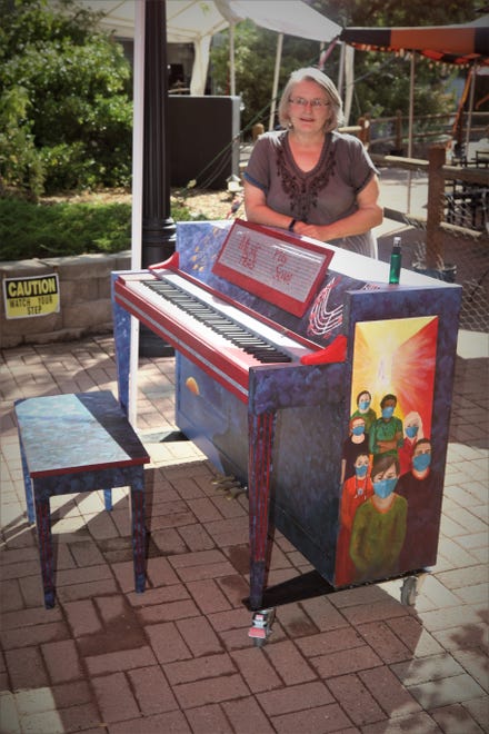 Artist Bonnie Adams poses with her piano featuring a theme promoting the healing power of music on Aug. 15, 2020, at the Main Avenue Plaza in Aztec.