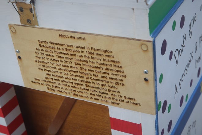 Each piano has a plaque attached to the back that features a short biography of the artist who painted it.