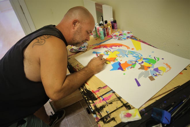 Artist Ryan Callisto works on a portrait of the Beatles in his new gallery in Aztec on Aug. 17, 2020.