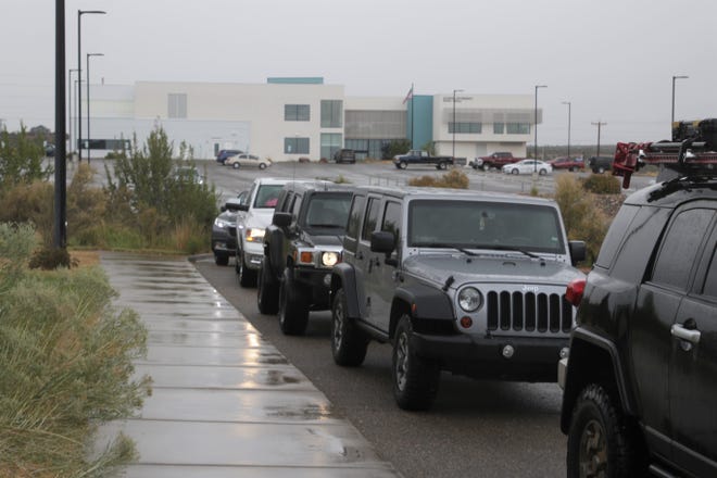 Vehicles line up at  at San Juan College's Quality Center for Business for food boxes and free trees on Wednesday, Sept. 9, 2020, in Farmington.