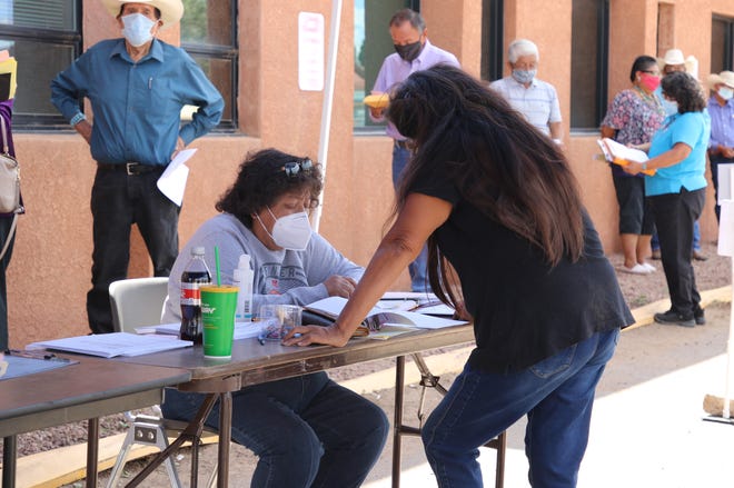 An employee with the Navajo Election Administration helps an individual file candidacy paperwork on Aug. 10, 2020 in Window Rock, Arizona for the tribe's general election.
