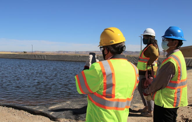 Gallup Mayor Louis Bonaguidi, left, takes a photo of a sediment pond during a tour on Oct. 19 of the Cutter Lateral Water Treatment Plant near Dzilth-Na-O-Dith-Hle.
