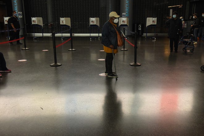 A person waits in line to vote at the Barclays Center during early voting for the U.S. Presidential election on October 24, 2020 in the Brooklyn borough in New York City. Due to the coronavirus and social distancing concerns New York State is allowing early voting for the first time.