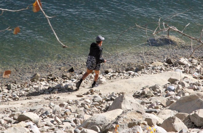 An angler walks along the shore, Friday, Nov. 6, 2020, at Navajo Lake.