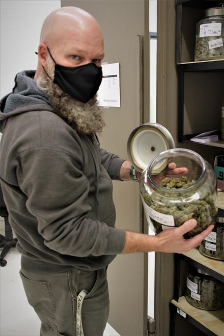Jason Little of Farmington's New Mexico Alternative Care removes the lid from a jar of one of his varieties of medical marijuana on Nov. 12, 2020.